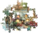Legpuzzel van 1500 stukjes, deels gelegd, met een huisje met waterrad en bloeiende bloemen.