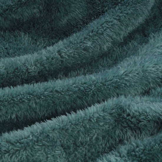 Gedetailleerde close-up van een zachte, pluizige teal gekleurde stof met golvende plooien.