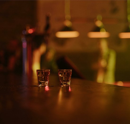 Barman Met Een Borrelglazen Van Mexicaanse Tequila Op Teller Stock Foto Barman Met Een Borrelglazen Van Mexicaanse Tequila Op Teller Stock Foto