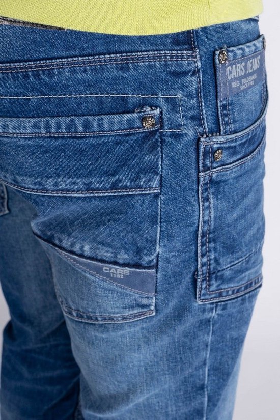 Detail van een blauwe spijkerbroek met Cars Jeans logo's op de achterzak en een label.