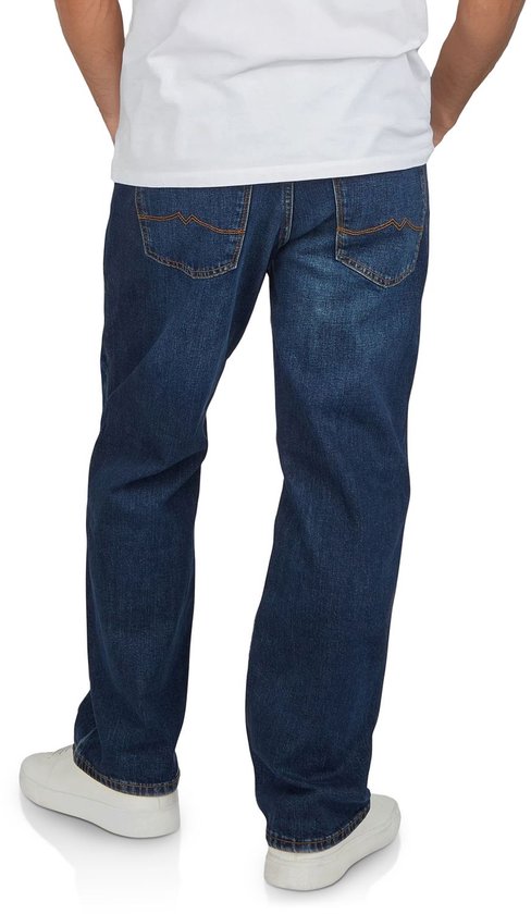 Achterkant man in blauwe jeans, licht vervaagd, rechte pijpen en witte sneakers.