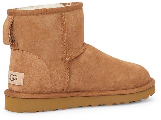 Bruine UGG laars met een suède afwerking, bruine zool en een UGG logo op de zijkant.