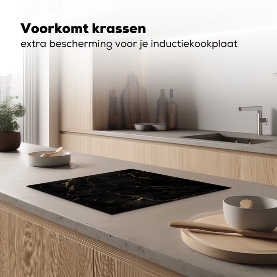 Zwarte inductiebeschermer met marmerprint, liggend op een aanrechtblad in een moderne keuken.