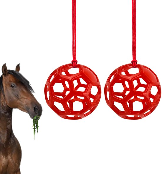 Twee rode hooivoederballen van kunststof, rond met honingraatmotief. Met een paard dat hooi eet op de achtergrond.
