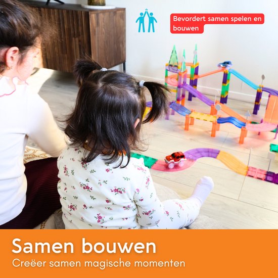 Twee kinderen spelen samen met een magnetische racebaan. Samen bouwen. Creëer samen magische momenten.