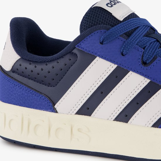 Detail van de zool van een blauwe Adidas sneaker met witte strepen.