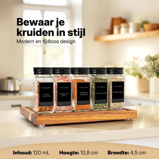 Cinq bocaux à épices en verre avec couvercles noirs sur une planche en bois. Avec étiquettes : Flocons de piment, Sel de l'Himalaya, Paprika en poudre, Basilic, Fenouil.