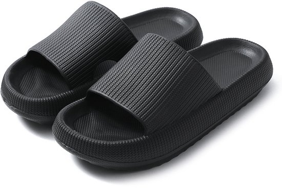 Zwarte slippers met dikke, gegroefde zolen.