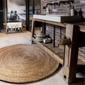 Rond vloerkleed in naturel jute met een cirkelvormig gevlochten patroon.