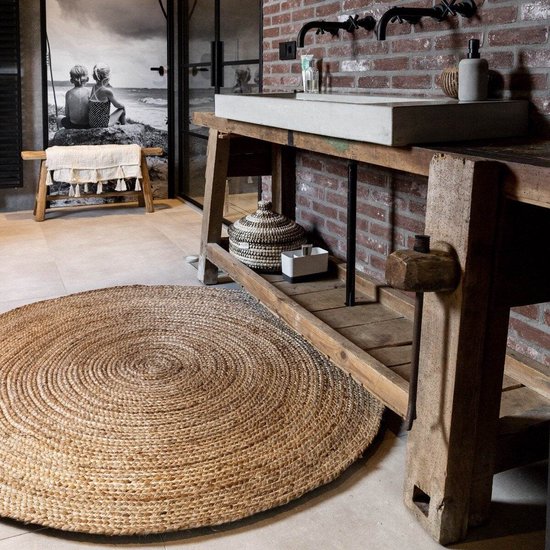 Rond vloerkleed in naturel jute met een cirkelvormig gevlochten patroon.