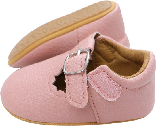 Roze babyschoentje met gesp, geschulpte randen en klittenbandsluiting aan de achterkant.