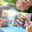 Kaart met roze rozen en gestapelde boeken, versierd met diamanten.