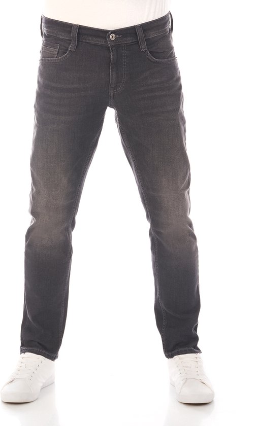 Man in een zwarte tapered fit jeans met witte sneakers.