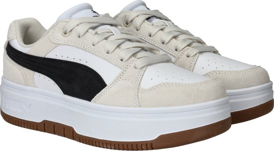 Witte Puma sneakers met beige suède details, zwarte streep, dikke witte zool en bruine rand.