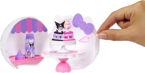 Hand die miniatuur taart decoreert in Miniverse Make It Mini Hello Kitty en Friends display.