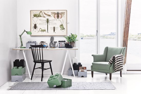Werkruimte met bureau, stoel en groene Lego-opbergdozen.