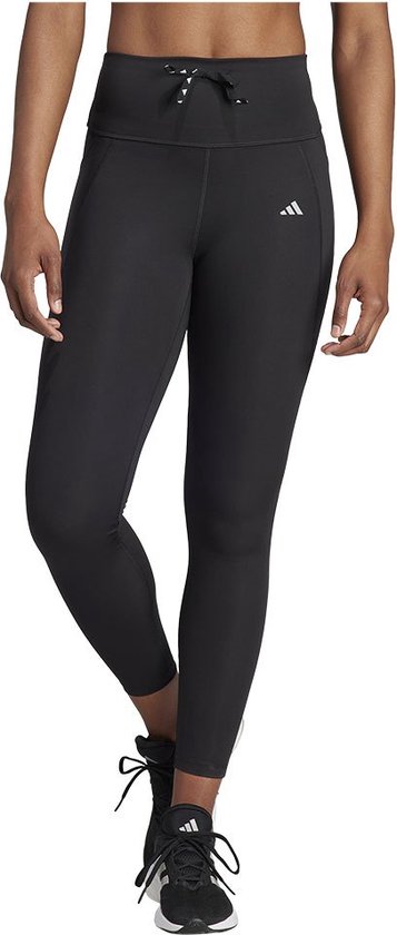 Model in zwarte Adidas legging met trekkoord en zwarte sneakers.