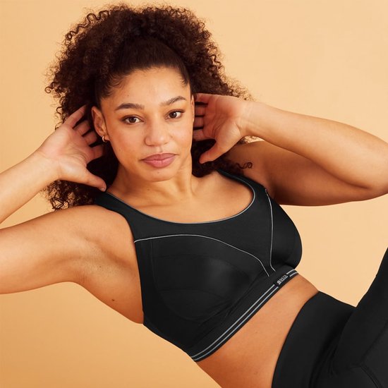 Zwarte sportbeha van Shock Absorber met witte accentlijnen en een grijze band, gedragen door een model.