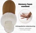 Bovenkant van een bruine pantoffel met witte teddy voering en een afbeelding van een hand die memory foam indrukt.