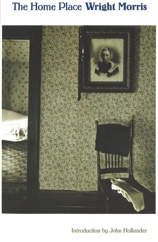 Boekomslag van 'The Home Place' met een zwart-witfoto van een stoel met een handdoek, een ingelijste foto aan de muur, en een bed in de verte.