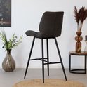 Antracietkleurige barkruk met horizontale stiksels, gezien vanaf de zijkant, in een interieur.