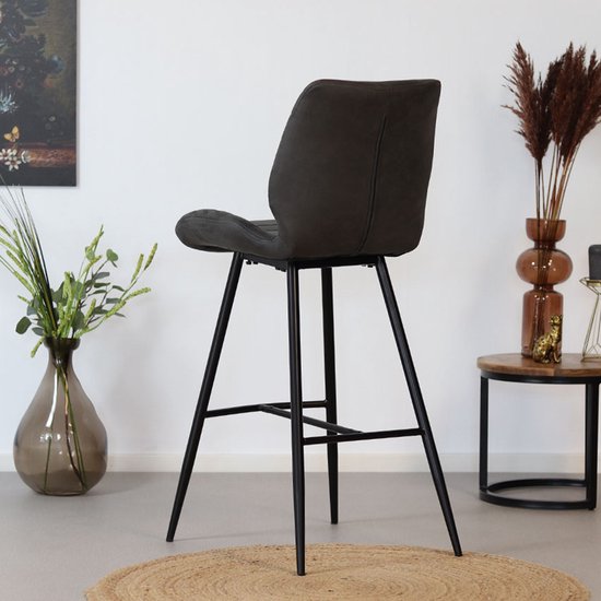 Antracietkleurige barkruk met horizontale stiksels, gezien vanaf de zijkant, in een interieur.