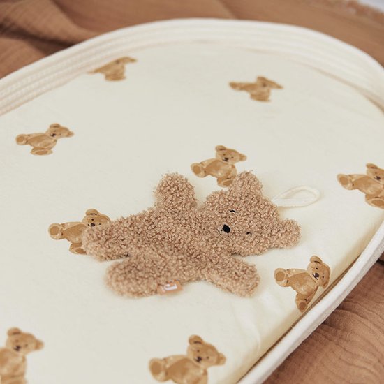 Drap de lit crème à imprimé ours en peluche, avec un ours en peluche en tissu dessus.