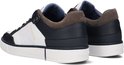 Zijkant van twee witte sneakers met marineblauwe en bruine suède accenten, met 'G-STAR RAW' op de zijkant.