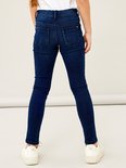 Model draagt een donkerblauwe skinny jeans, achterkant zichtbaar.