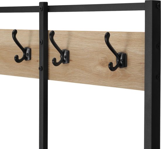 Detail van houten paneel met zwarte kapstokhaken.