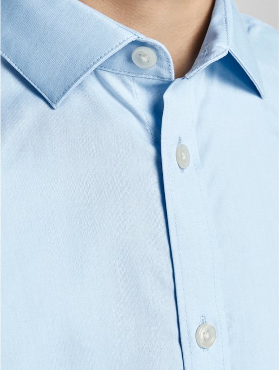 Fermeture d'une chemise bleu clair en coton avec des boutons blancs.