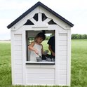 Meisje in wit speelhuisje speelt met kookgerei in de speelkeuken. Op de achtergrond een jongen.