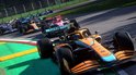 Oranje Formule 1 auto op het circuit, andere auto's in de race op de achtergrond.