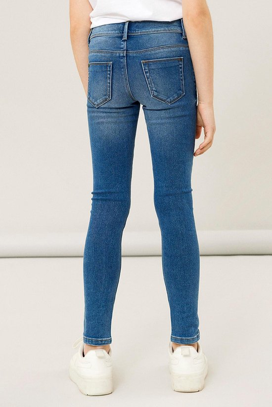 Meisje in skinny spijkerbroek, achterkant.