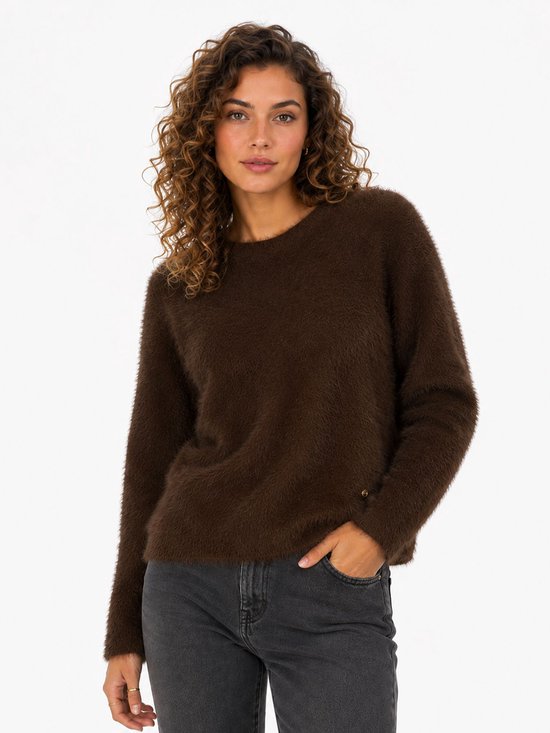 Model met een bruine, pluizige trui met ronde hals en lange mouwen.