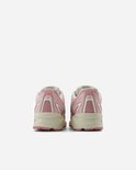 Achterkant van roze New Balance sneakers met beige zolen.