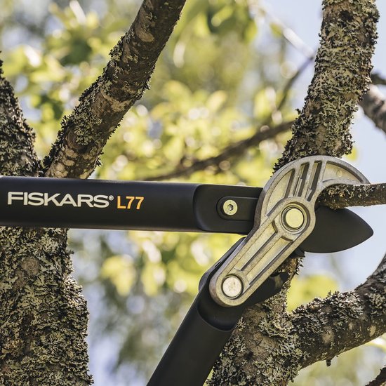 Close-up van Fiskars L77 takkenschaar die een tak doorknipt.