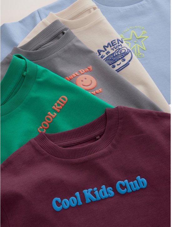 Stapel van vijf kinder T-shirts in verschillende kleuren: bordeaux, crème, groen, grijs en lichtblauw.
