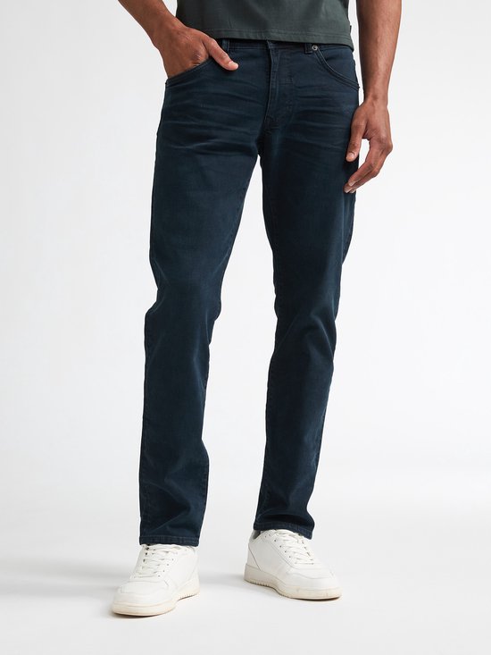 Close-up van donkerblauwe jeans met zakken, gedragen door een man.