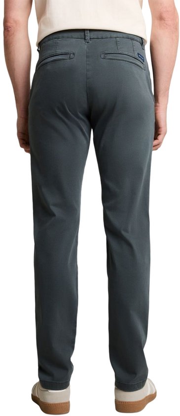 Donkergroene chino van Tom Tailor, gedragen door een man van achteren gezien.