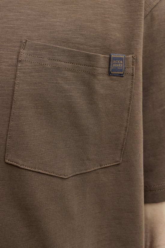 Detail van een bruin t-shirt met borstzakje en Jack & Jones label.