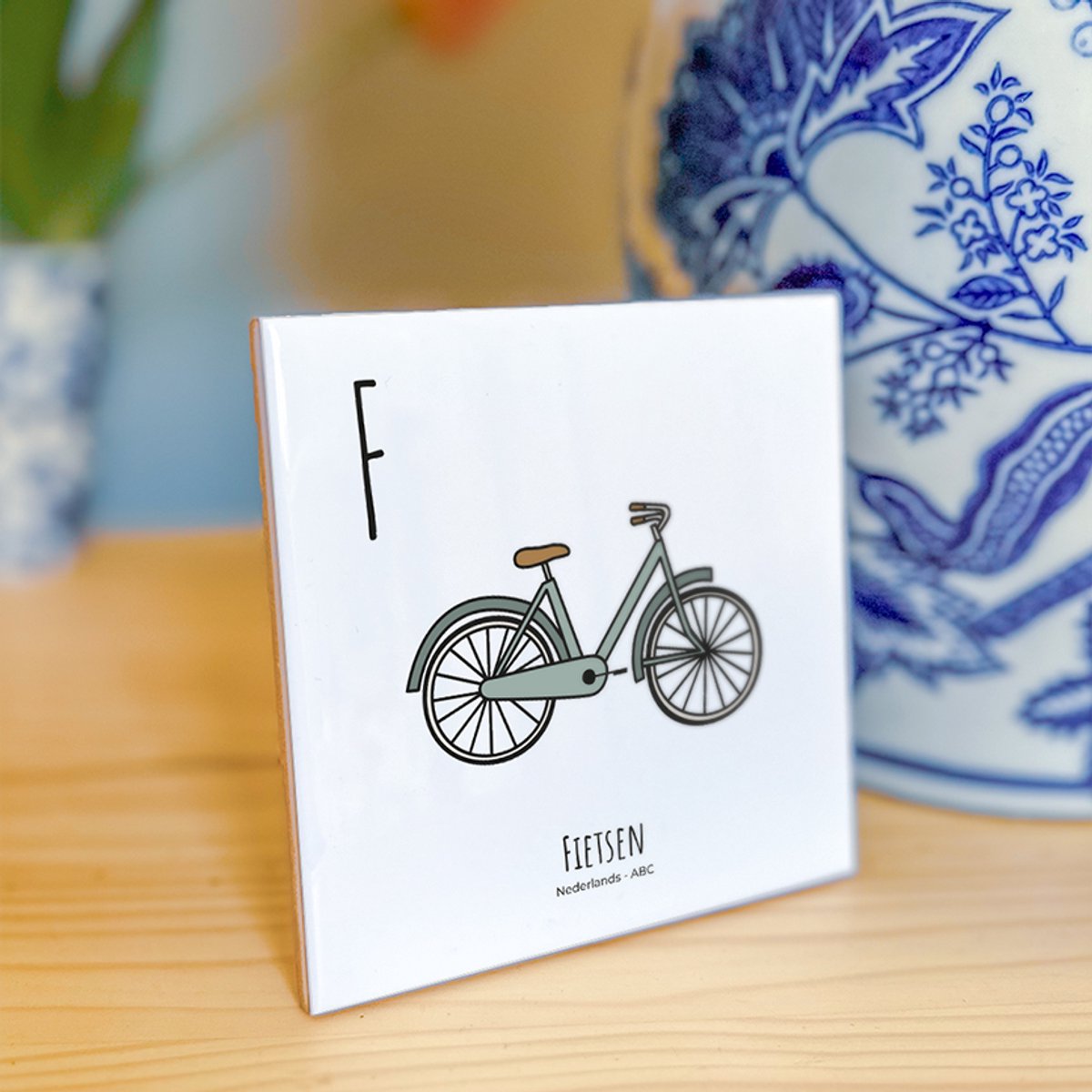 Fietsen - ABC tegeltje Nederland - Keramiek met Handgetekende Illustratie - Wanddecoratie - Woondecoratie - Relatiegeschenk - Souvenir - 10,8 x 10,8 cm