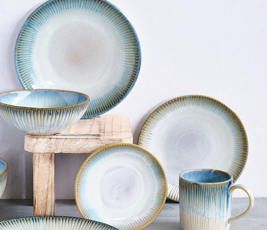 Servies met verticale groeven in blauw, wit en goudkleurig, close-up.