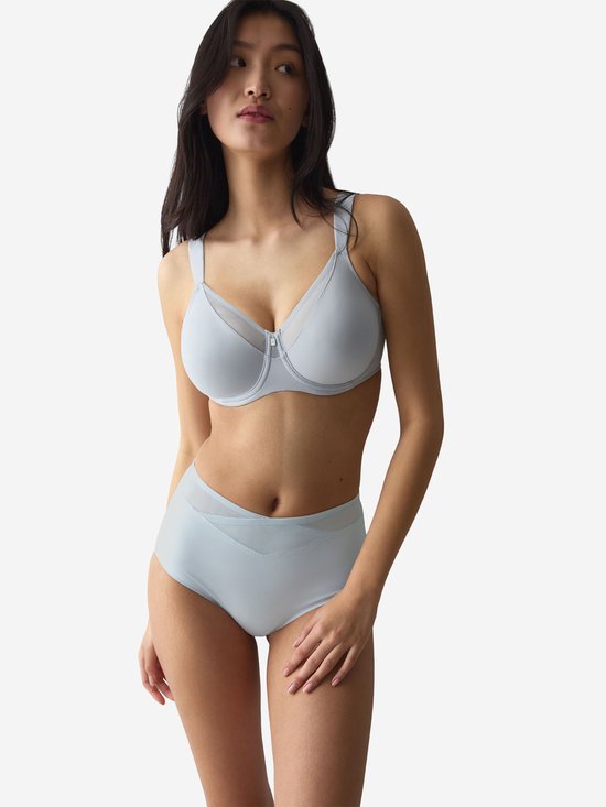 Vrouw, zijkant, in lichtblauwe beha en slip met mesh details.