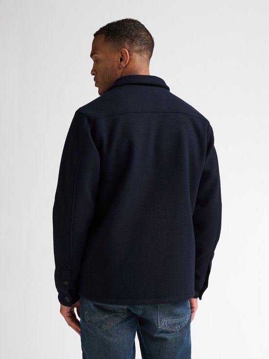Achterkant van donkerblauw Petrol Industries overshirt met wol-look op een model met jeans.