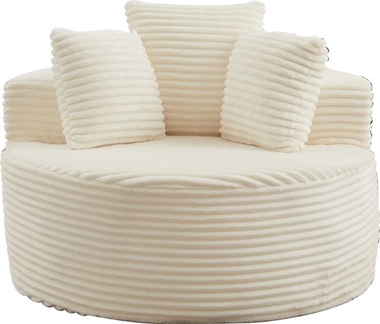 Crèmekleurige corduroy fauteuil met ribbelpatroon en vier bijpassende kussens, gefotografeerd op een zwarte achtergrond.