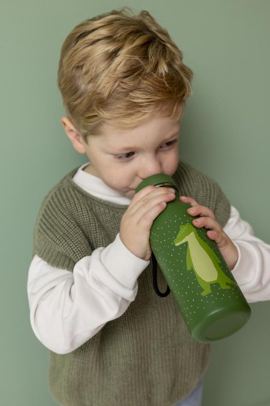 Groene drinkfles met witte stippen en een lichtgroene krokodil. Een jongen drinkt eruit.