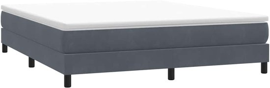 Donkergrijs fluwelen boxspring bedframe met een witte topper, op vier zwarte pootjes.