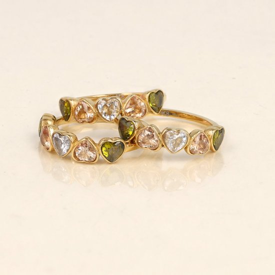 Twee gouden ringen met hartvormige stenen in groen, lichtroze en wit.
