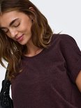 Close-up van een model met donkerpaarse top met glitterdetails.